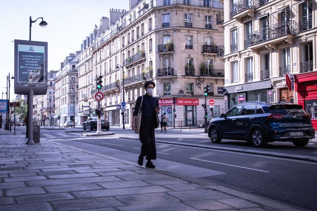 A man wearing a face mask walks along an almost deserted street in Paris, France, during the quarantine on April 19.