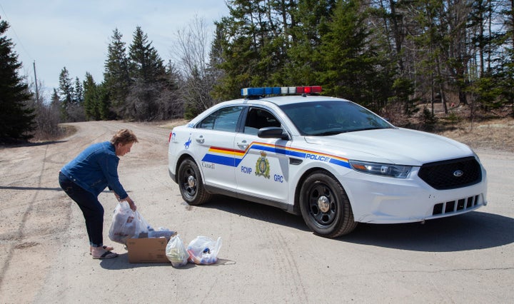 Local resident Juanita Corbett delivers food and drinks to police on Portapique Beach Road after Sunday's deadly shooting rampage on April 20, 2020 in Portapique, N.S.