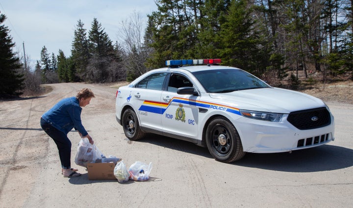 Local resident Juanita Corbett delivers food and drinks to police on Portapique Beach Road after Sunday's deadly shooting rampage on April 20, 2020 in Portapique, N.S.