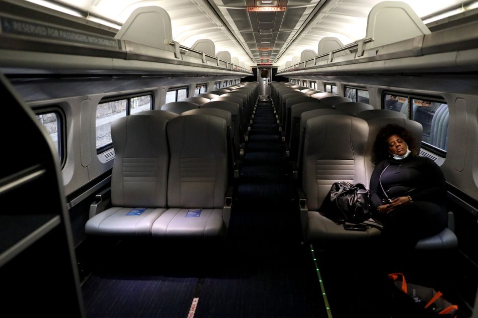 A lone passenger sleeps in an otherwise empty Amtrak car as the train pulls into Penn Station on April 9, 2020, in Baltimore.