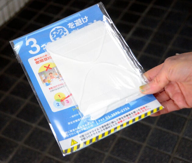 各家庭に配布された布マスク。「3つの密を避けましょう!」と書かれた案内が添えられている=17日、東京都世田谷区