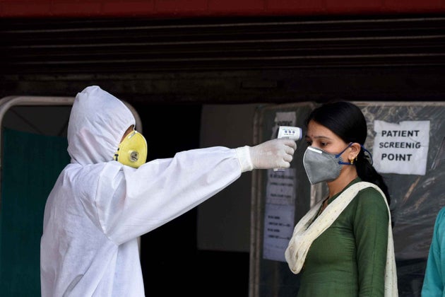 A visitor undergoes thermal screening at the entry point to the city hospital during lockdown, at IP...