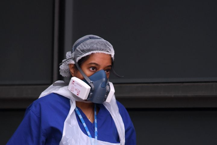 A nurse wears a protective face mask as she walks outside The Royal London Hospital in east London 