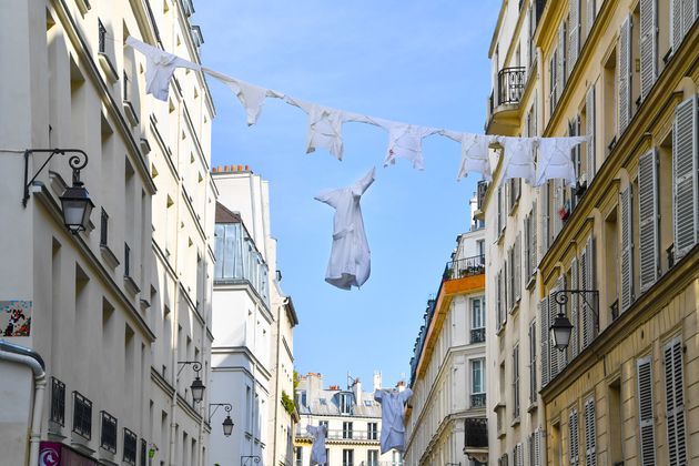 En hommage aux soignants, des blouses sont suspendues dans la rue durant le confinement, à Paris...