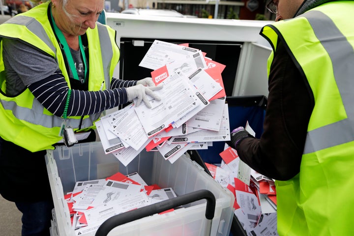 King County Election workers collect ballots from a dropbox in the Washington state primary on March 10, 2020, in Seattle. Washington is a vote-by-mail state. 