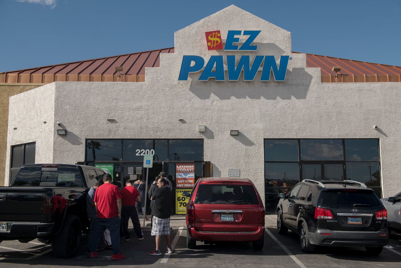 Customers wait in line outside an EZPawn on April 13, 2020, in Las Vegas.