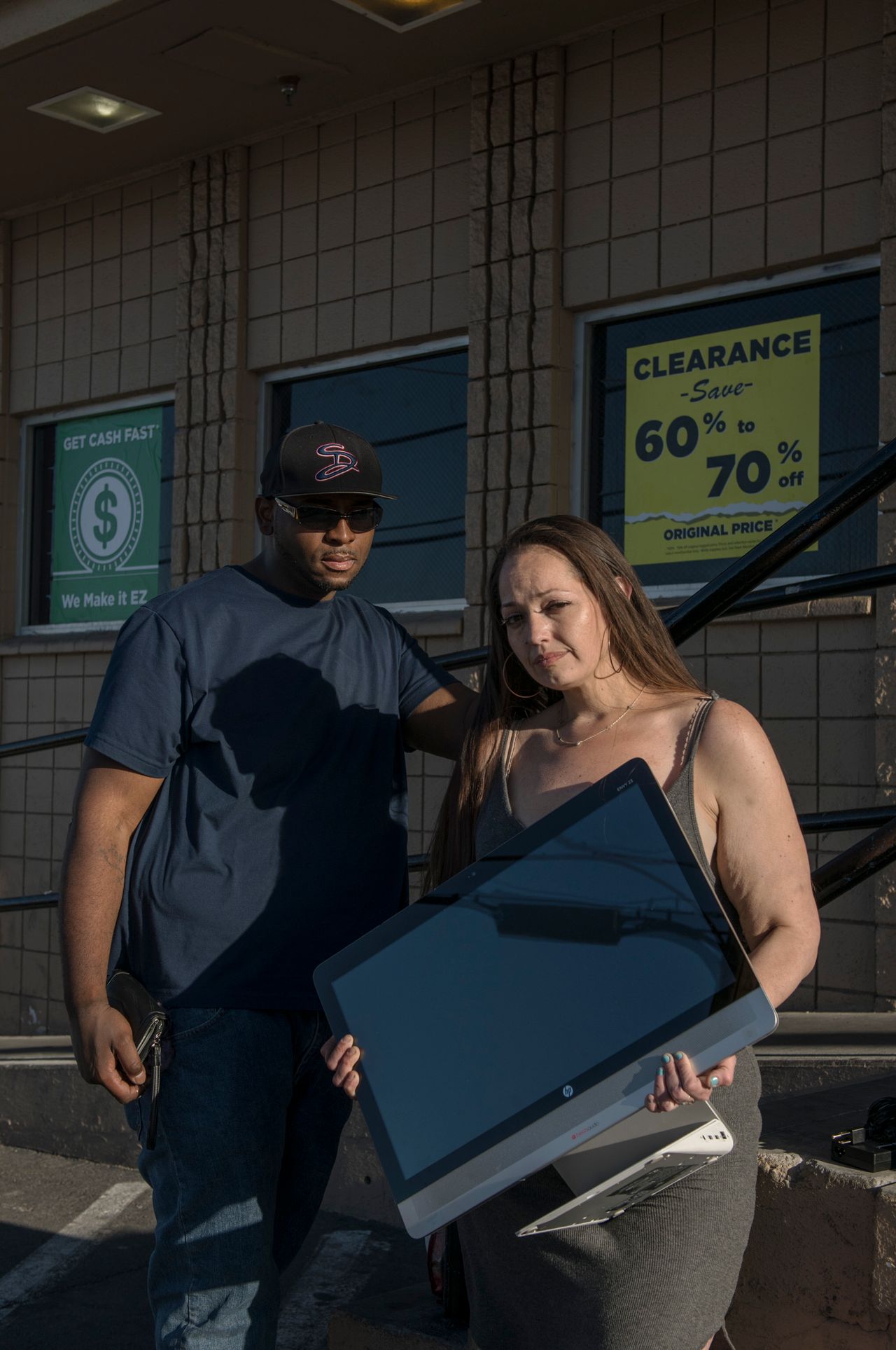 Cue and Sara Lovato wait in line with a computer they're hoping to sell at an EZPawn on April 13, 2020. “Gotta get some gas,” said Sara. Her work in behavioral health has been affected by the coronavirus.