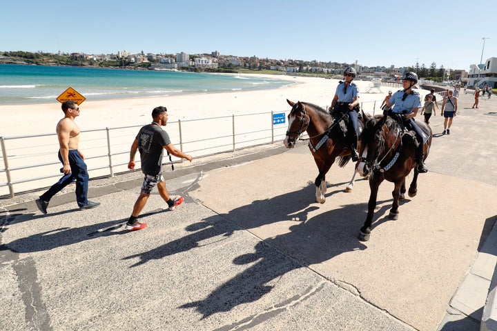 Police officers ride horses as they patrol during a partial lockdown imposed due to the coronavirus in Bondi Beach, Sydney, Australia,