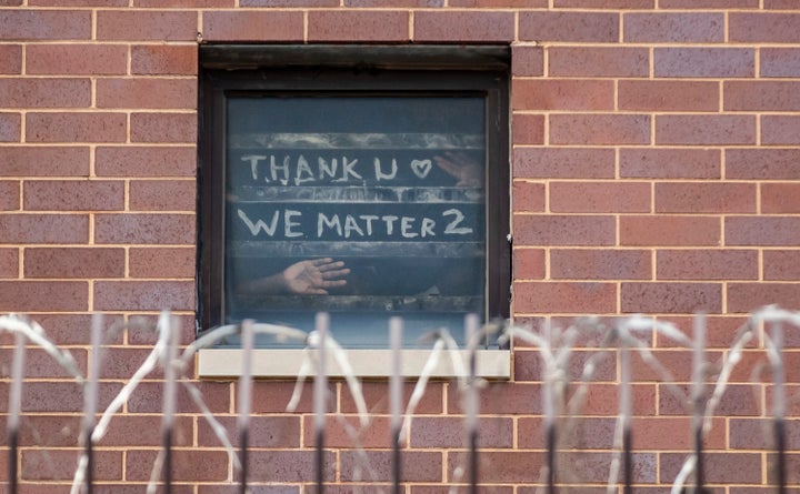 Inmates inside Cook County Jail post messages in the window and signal to protestors outside on April 12 during the coronavirus pandemic. (Brian Cassella/Chicago Tribune/Tribune News Service via Getty Images)