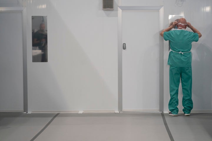 A hospital worker puts on personal protective equipment (PPE) to avoid being infected or transmitting coronavirus during a training session at the Nightingale Hospital North West in Manchester