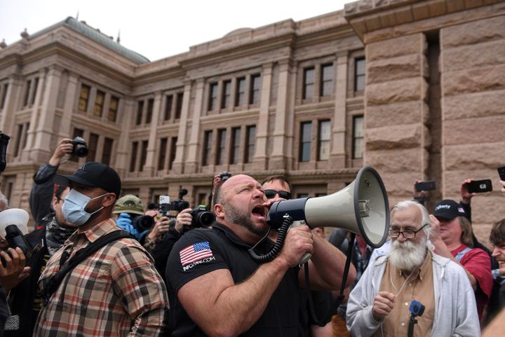 Alex Jones screams into a megaphone as protesters against the state's extended stay-at-home order to help slow the spread of the coronavirus disease (COVID-19) demonstrate at the Capitol building in Austin, Texas, April 18, 2020.