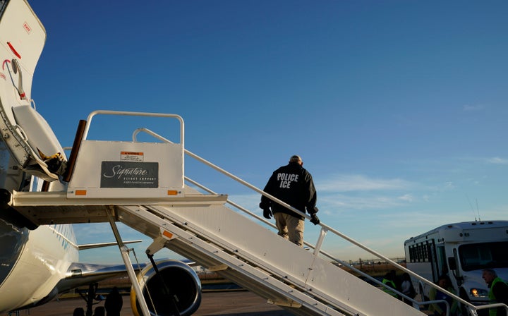 An Immigration and Customs Enforcement officer watches as immigrants are deported by plane in 2018.