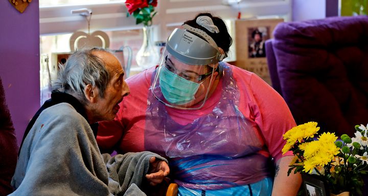 A nurse in PPE speaks to a resident at the Wren Hall care home in Nottingham, Monday, April 20.