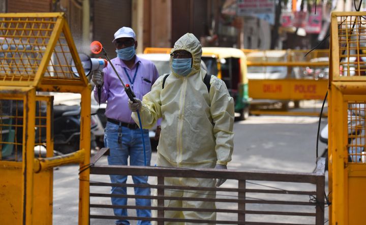 An East Delhi Municipal Corporation (EDMC) worker chemically disinfects an area in Pandav Nagar on April 22, 2020 in New Delhi.