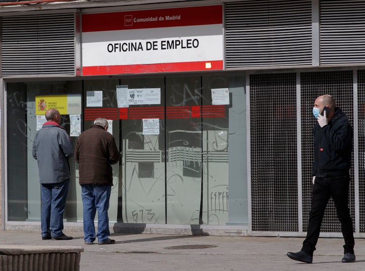 Dos personas miran la oficina de empleo tras la declaración del estado de alarma.