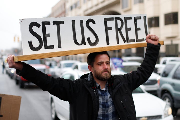 Steve Polet holds a sign during a protest at the State Capitol in Michigan last week 