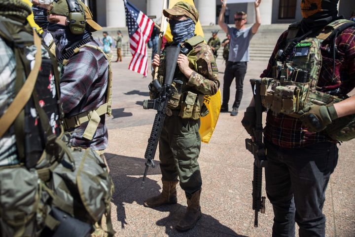 A local militia group is seen at a rally to protest a stay-at-home order in Columbus, Ohio, on April 20. The man in the center is wearing a "boogaloo" patch.