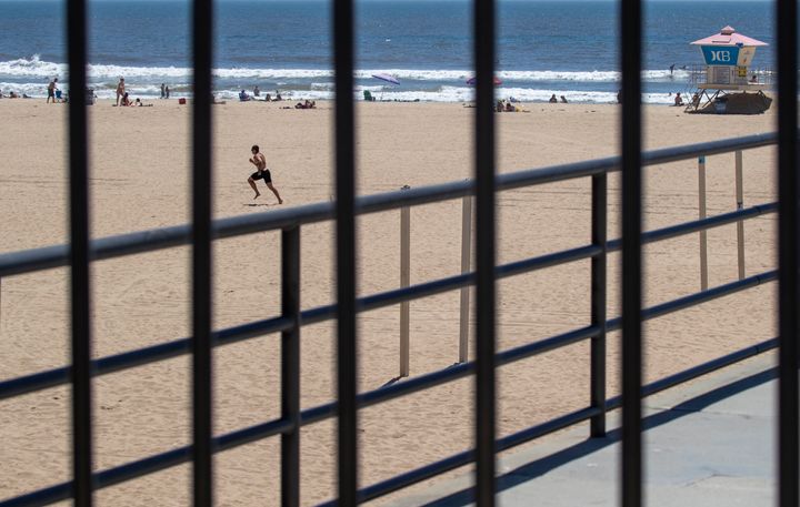  22 Απριλίιου, 2020. Ελάχιστοι λούμενοι στην παραλία του Χάντιντον στην Καλιφόρνια στις ημέρες του κορονοϊού. Όμως το καλοκαίρι πλησιάζει... (Allen J. Schaben / Los Angeles Times via Getty Images)