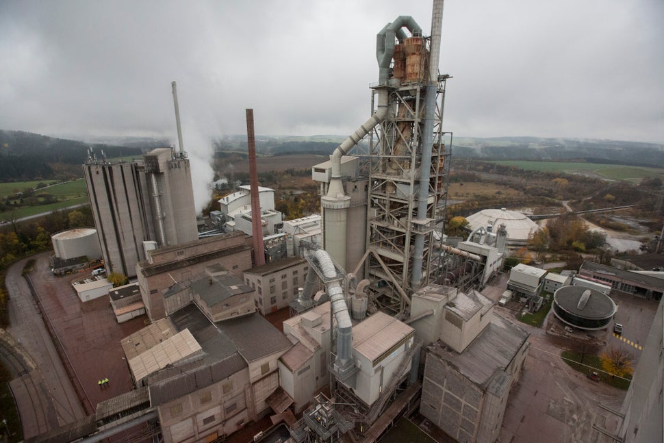 A cement kiln preheater tower, right, stands above factory buildings and storage silos at Holcim cement plant in Dotternhause