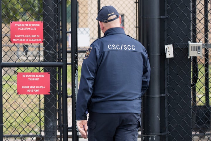 A guard walks through a gate at Bath Institution near Kingston, Ont. on Oct. 17, 2018.