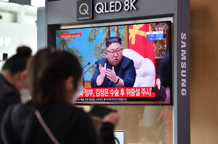 People watch a television news broadcast showing file footage of North Korean leader Kim Jong Un, at a railway station in Seoul on April 21.