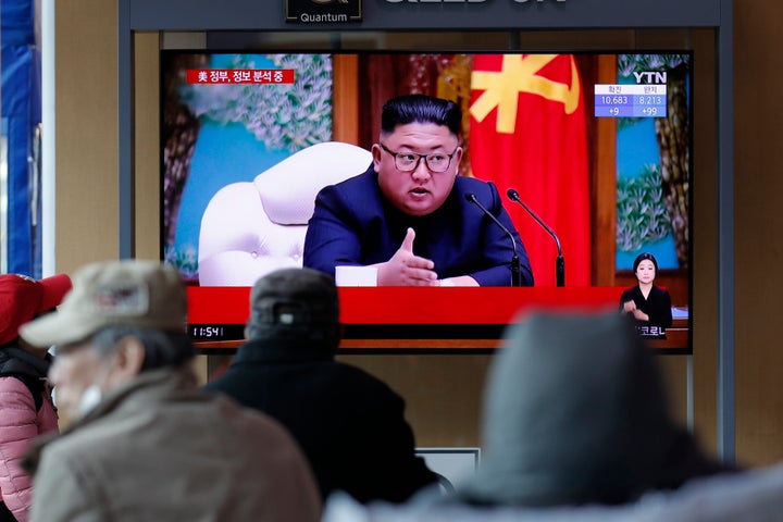 People watch a TV screen showing a news program reporting about North Korean leader Kim Jong Un with a file image at the Seou