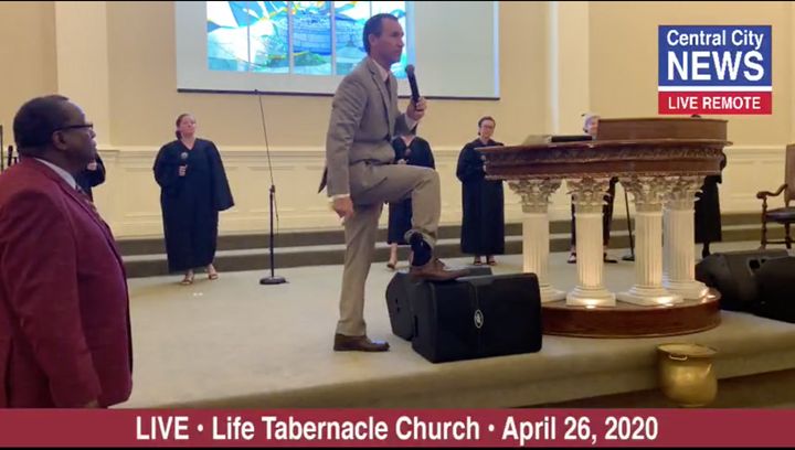 Pentecostal preacher Tony Spell shows off his ankle monitor during a church service on Sunday. Spell is under house arrest fo