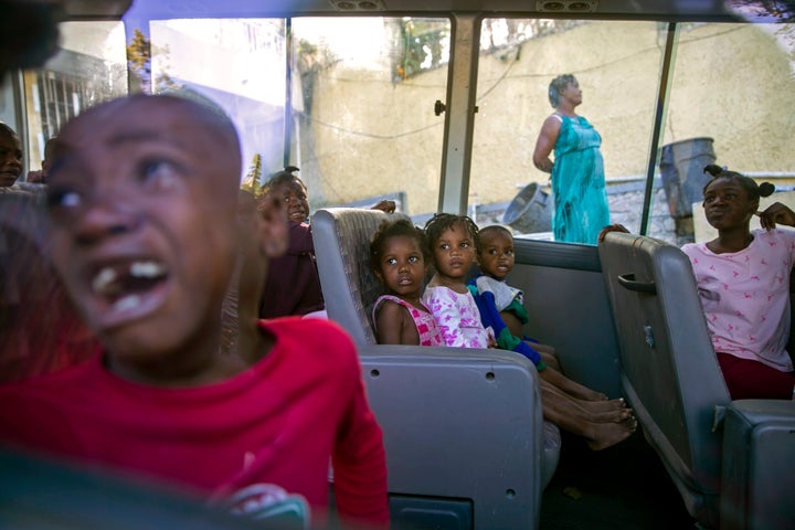 In this Feb. 14, 2020 file photo, orphans sit inside a social services bus after police removed them from a children's home r