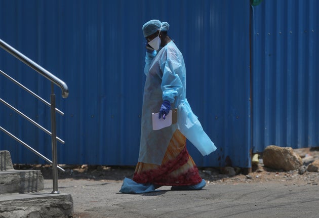 A health worker walks inside a containment zone to collect details during lockdown to prevent the spread...