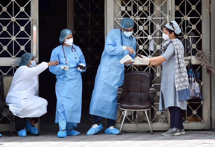 Doctors and medical staff of LNJP hospital attend to people outside the main building on April 25, 2020 in New Delhi.