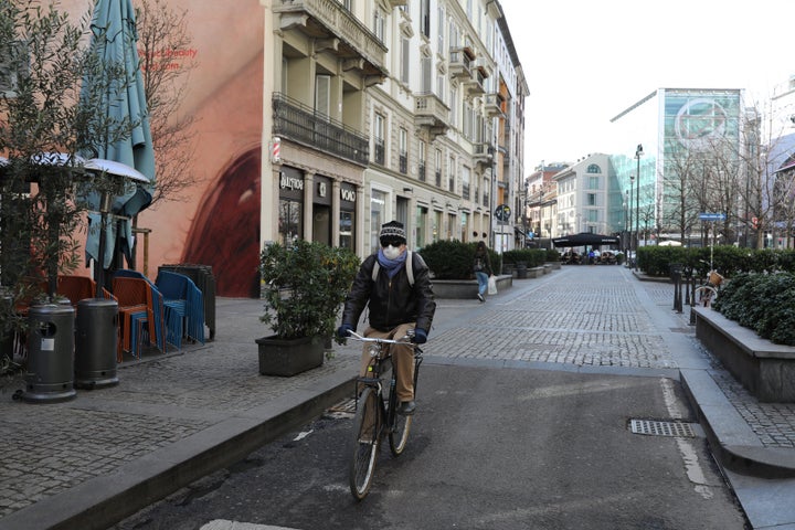 A man rides a bicycle on an empty Corso Garibaldi, a main road in the center of Milan, on February 26. In response to the coronavirus pandemic, the city plans to increase bike lanes and pedestrian paths and discourage car use.