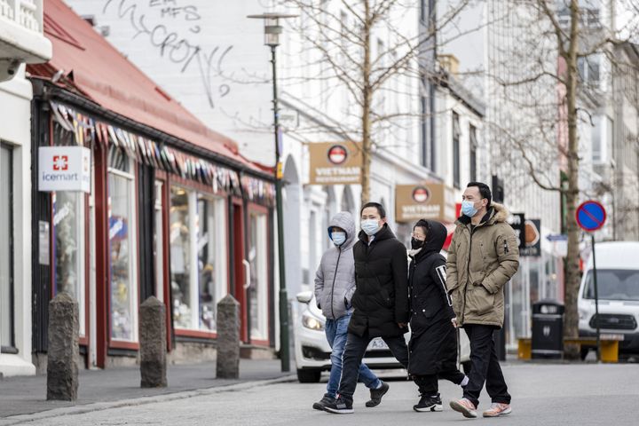 Tourists with masks walking down Bankastraeti street in downtown Reykjavik, April 3, 2020. 
