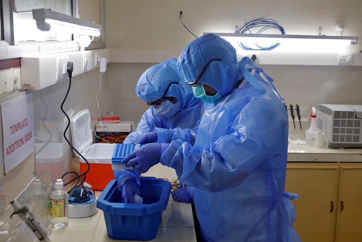 Microbiologists process COVID-19 tests in a lab at the Government Medical College in Kochi, April 17, 2020.