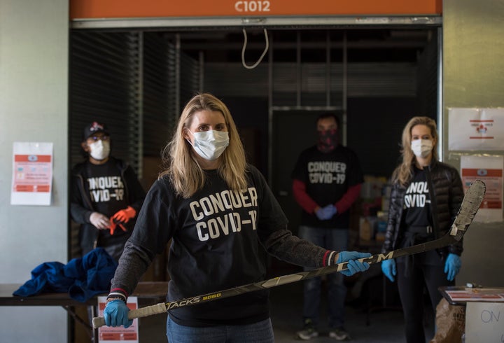 Hayley Wickenheiser poses for a photograph with volunteers during a donation drive for personal protective equipment at XYZ Storage in Toronto on April 11, 2020.