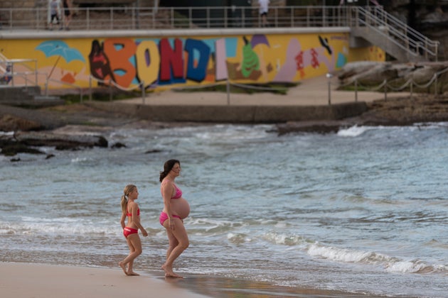 SYDNEY, AUSTRALIA - APRIL 28: A pregnant swimmer returns to Bondi beach on April 28, 2020 in Sydney, Australia. Waverley Council reopened Bondi, Bronte and Tamarama beaches today, with COVID-19 social distancing rules still in place. The beaches will be open from 7am to 5pm for swimmers and surfers on weekdays, but will remain closed on weekends. Several beaches in Sydney's Eastern suburbs were closed March 28, after large crowds were seen gathering at Bondi Beach despite social distancing orders in place to slow the spread of COVID-19. (Photo by Brook Mitchell/Getty Images)