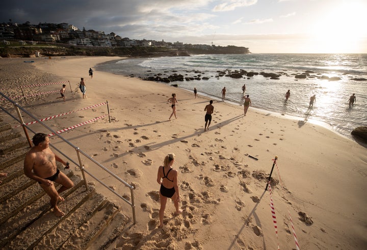 The first swimmers run into the water as Bronte Beach is reopened at Bronte Beach on April 28, 2020 in Sydney, Australia. (Photo by Ryan Pierse/Getty Images)