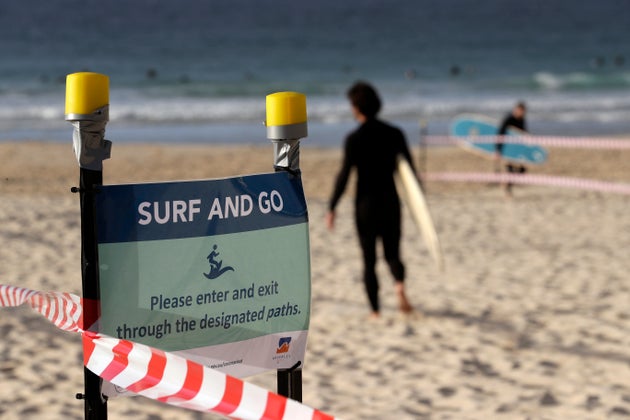 A sign tells surfers to leave once they have finished surfing at Bondi Beach in Sydney, Tuesday, April 28, 2020, as coronavirus pandemic restrictions are eased. The beach is open to swimmers and surfers to exercise only. (AP Photo/Rick Rycroft)