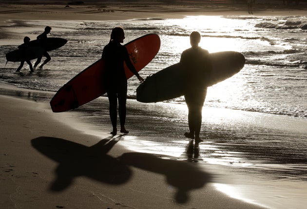 Surfers prepare to enter the water at Bondi Beach in Sydney, Tuesday, April 28, 2020, as coranavirus pandemic restrictions are eased. The beach is open to swimmers and surfers to exercise only. (AP Photo/Rick Rycroft)