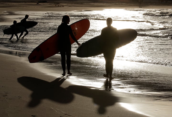 Surfers prepare to enter the water at Bondi Beach in Sydney, Tuesday, April 28, 2020. (AP Photo/Rick Rycroft)