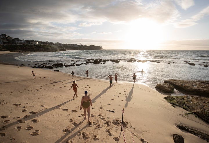 The first swimmers run into the water as Bronte Beach is reopened on April 28, 2020 in Sydney, Australia. (Photo by Ryan Pierse/Getty Images)