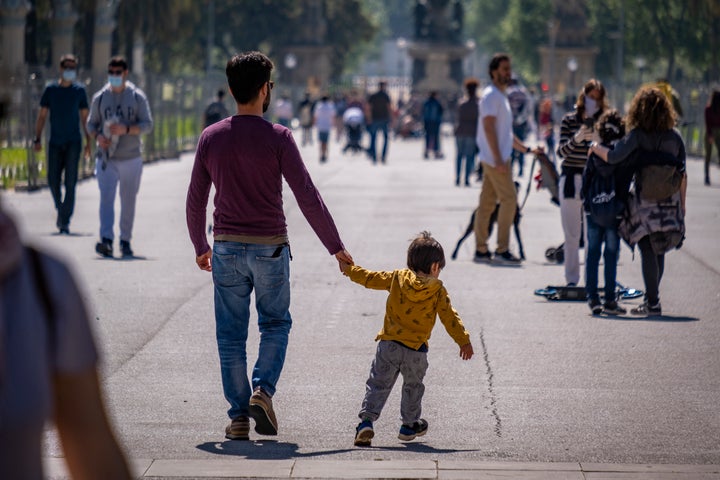 People in Barcelona, Spain, take a walk outside on April 26, the first day of allowing kids to go out for one hour with an adult.