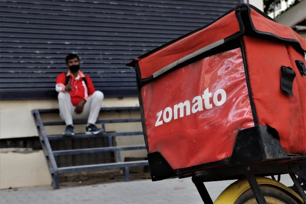 A Zomato food delivery boy takes rest near a closed shop amid COVID-19 (Coronavirus) lockdown in Gurugram...