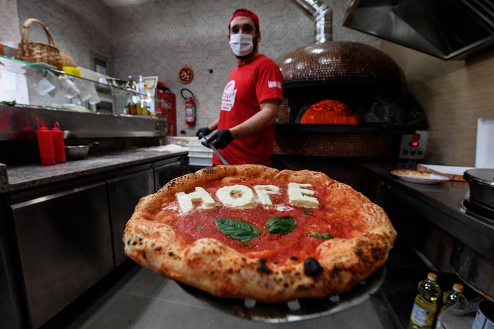 El pizzero napolitano Salvatore Rapuano muestra su pizza con la palabra 'Hope' (esperanza en inglés).