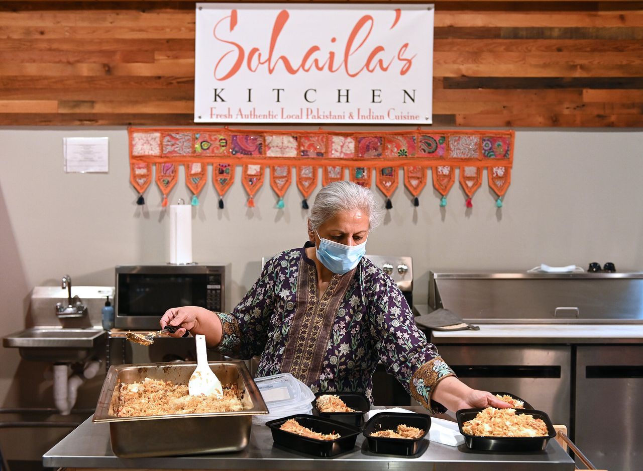 Sohaila Humayon of Sohaila's Kitchen in the Lenexa Public Market fills containers with rice for meals she is preparing for pickup Friday, Apr. 24, 2020.