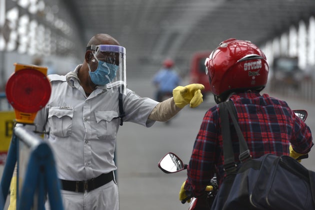 A West Bengal Police personnel directs a commuter at Howrah Bridge, on April 27, 2020 in
