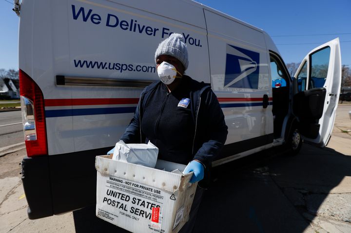 A United States Postal worker makes a delivery with gloves and a mask in Warren, Michigan, earlier this month.