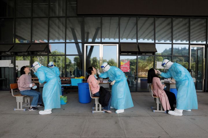 Medical workers from a hospital collect swabs from high school teachers for nucleic acid tests at a school, in Yichang, Hubei province, China April 27, 2020.