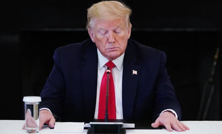 Donald Trump mirando un papel.