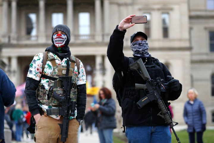 Protesters with rifles stand outside the state Capitol in Lansing, Michigan, on April 15 to demonstrate against Gov. Gretchen Whitmer's stay-at-home orders, meant to combat the coronavirus pandemic.