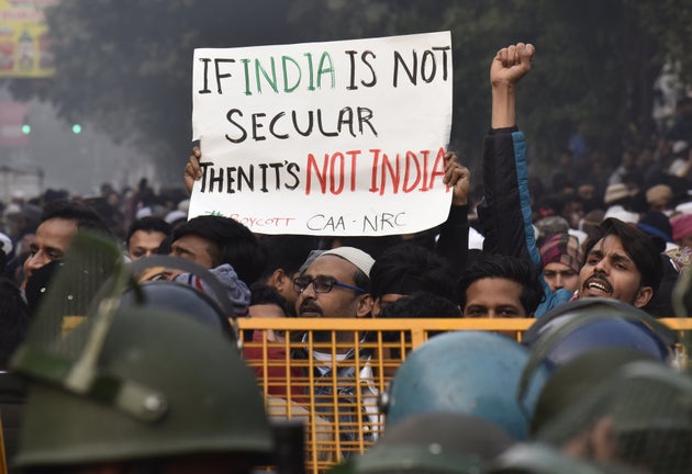 People hold placards and raise slogans during a protest against the Citizenship Amendment Act (CAA),...